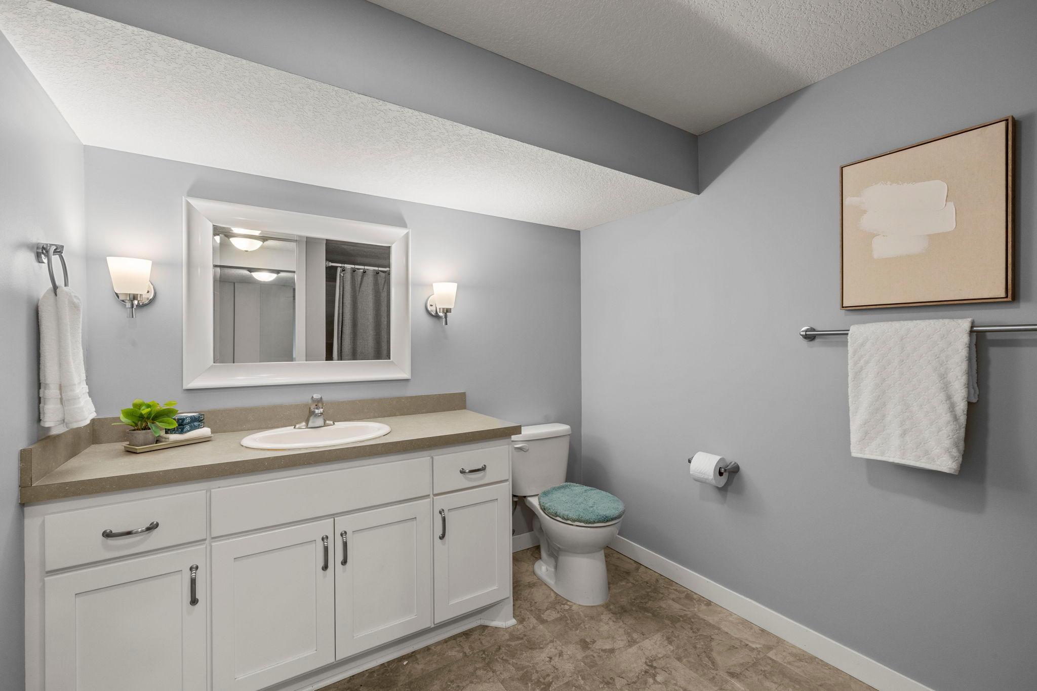 A nearby ¾ bathroom offers a walk-in shower and extended vanity space.