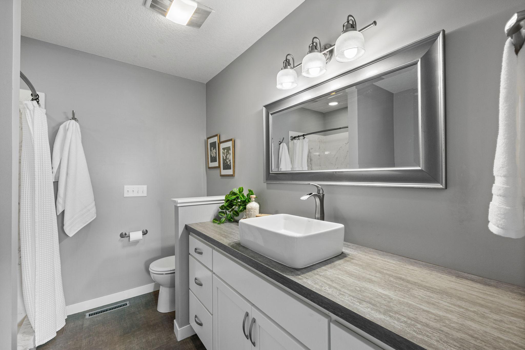 The ensuite bathroom includes a soaking tub, walk-in shower, and vanity.