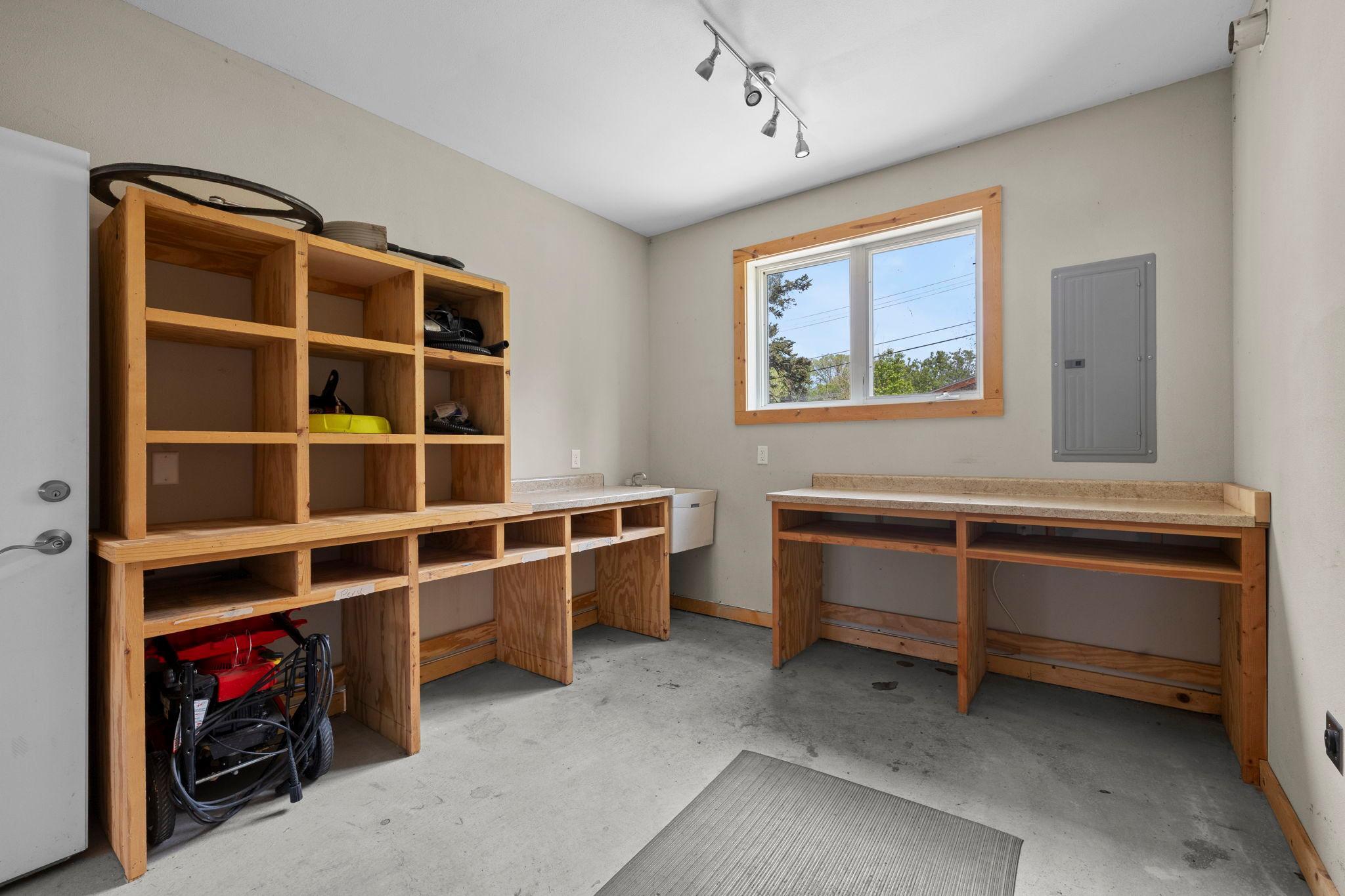 Connected workshop space featuring a workbench and shelving, ideal for tools, projects, and additional storage.