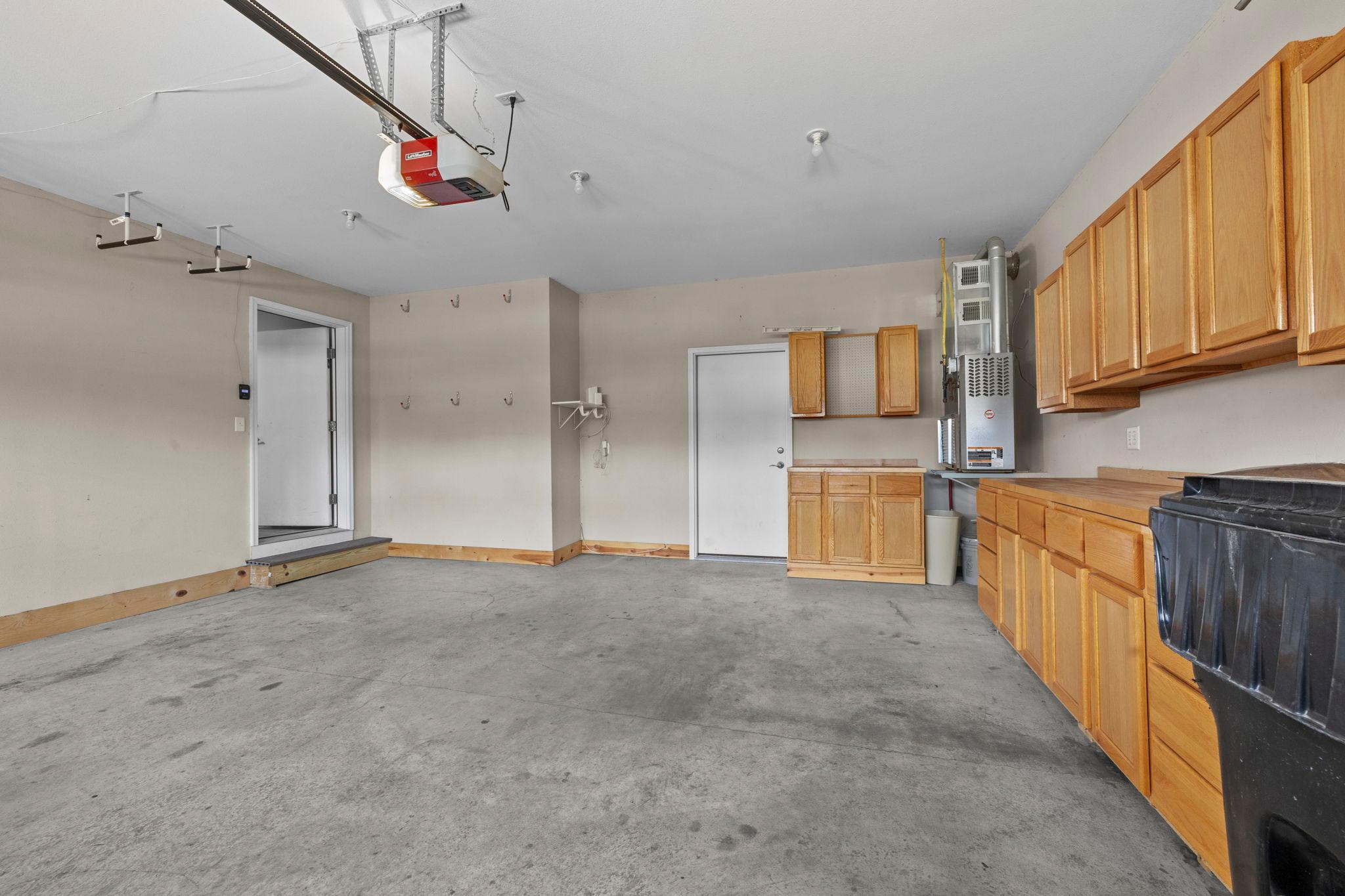 The property also includes a heated, 2-car, attached garage for year-round vehicle protection with cabinetry and counter workspace.