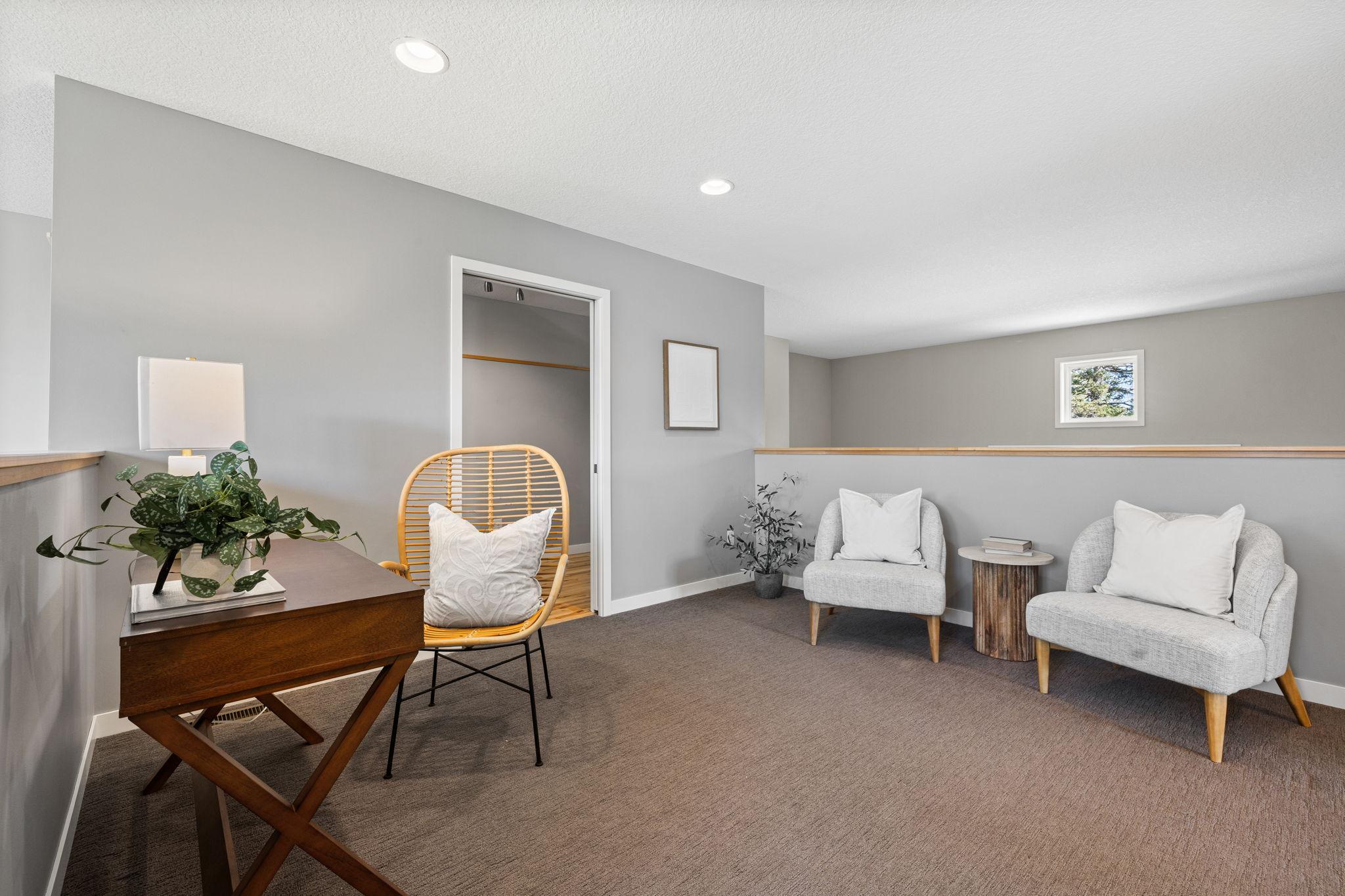 Upstairs, a versatile loft provides an ideal sitting area or informal office space with cozy carpeting.