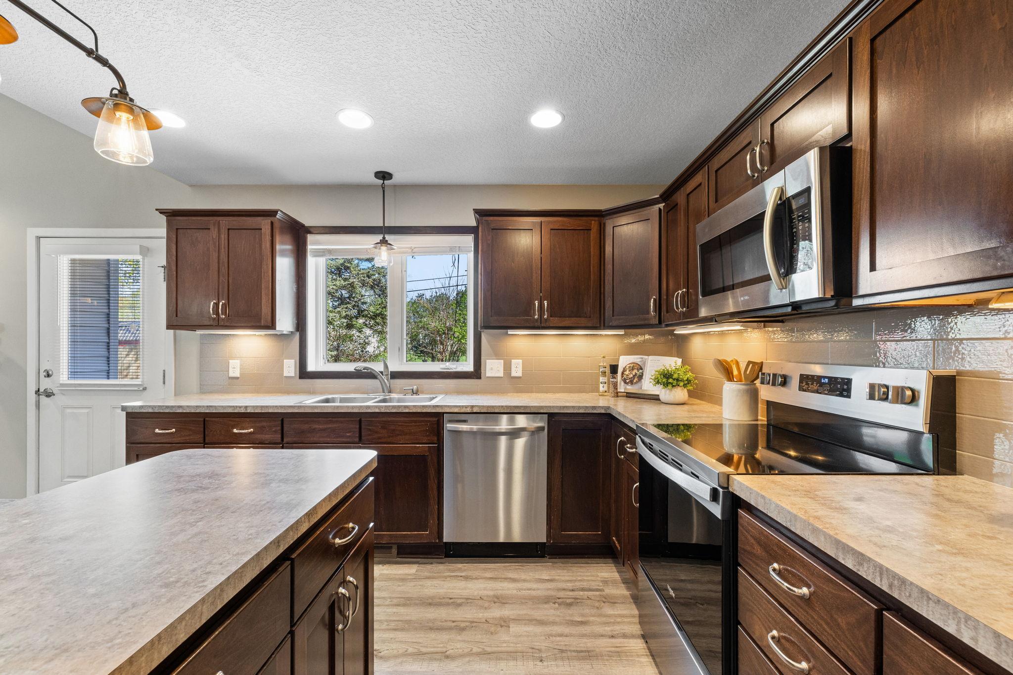 The kitchen is both stylish and functional, featuring stainless steel appliances and tile backsplash.