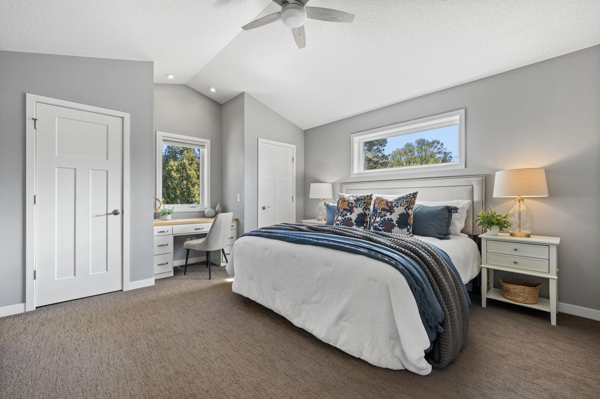 The primary bedroom continues with vaulted ceilings, dual closets, and a built-in desk.