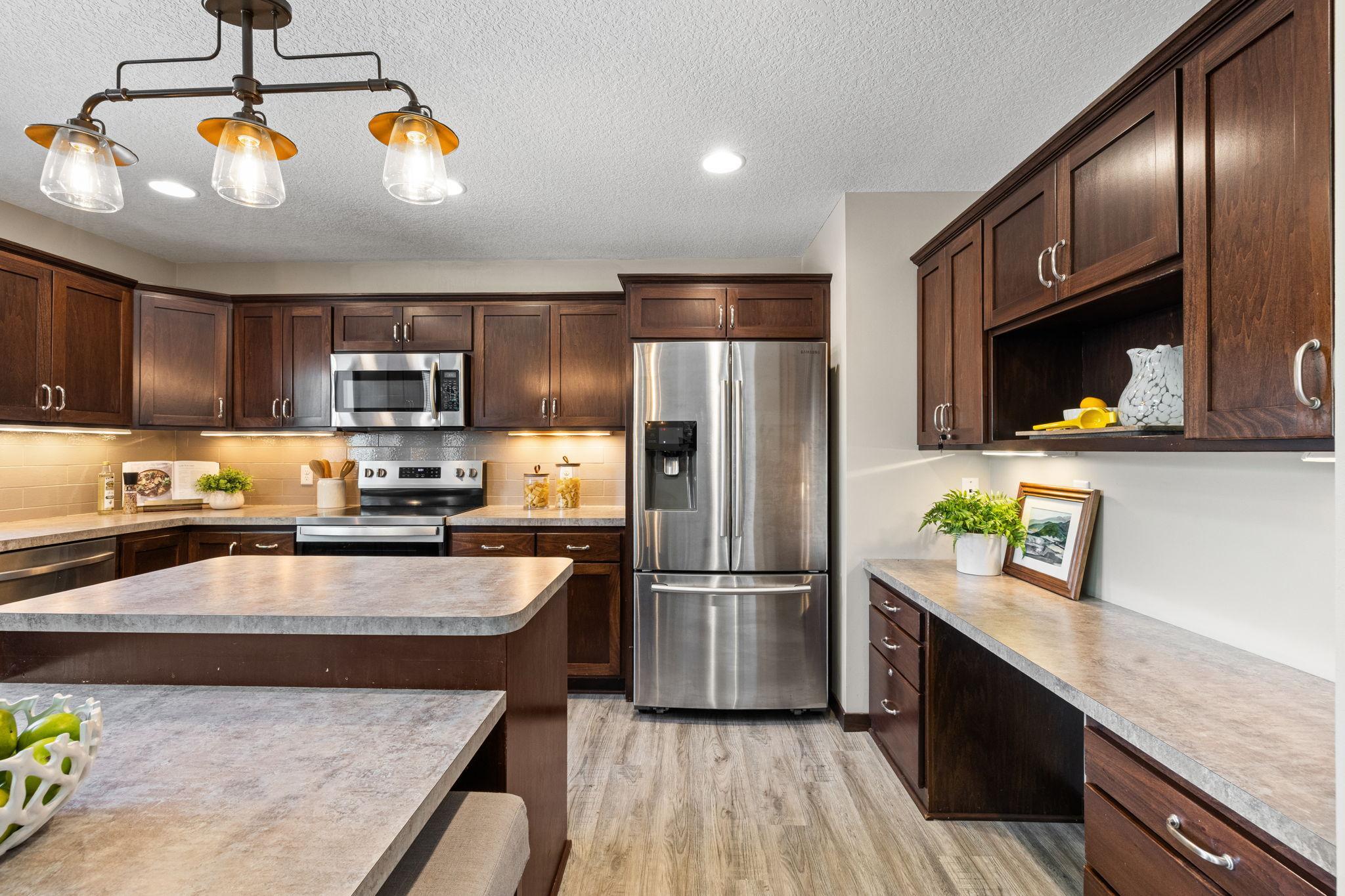 Walk-in pantry, under-cabinet lighting, and a built-in desk and drop zone for added organization.