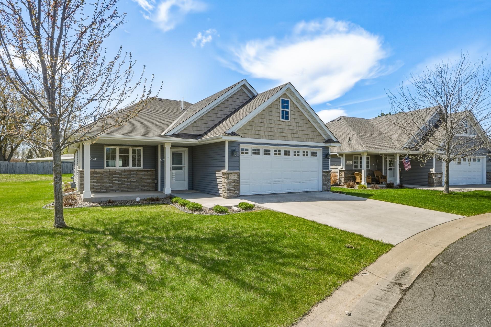 Concrete driveway, front covered porch, no exterior/interior stairs, and brick/shake siding add so much charm to the curb appeal.
