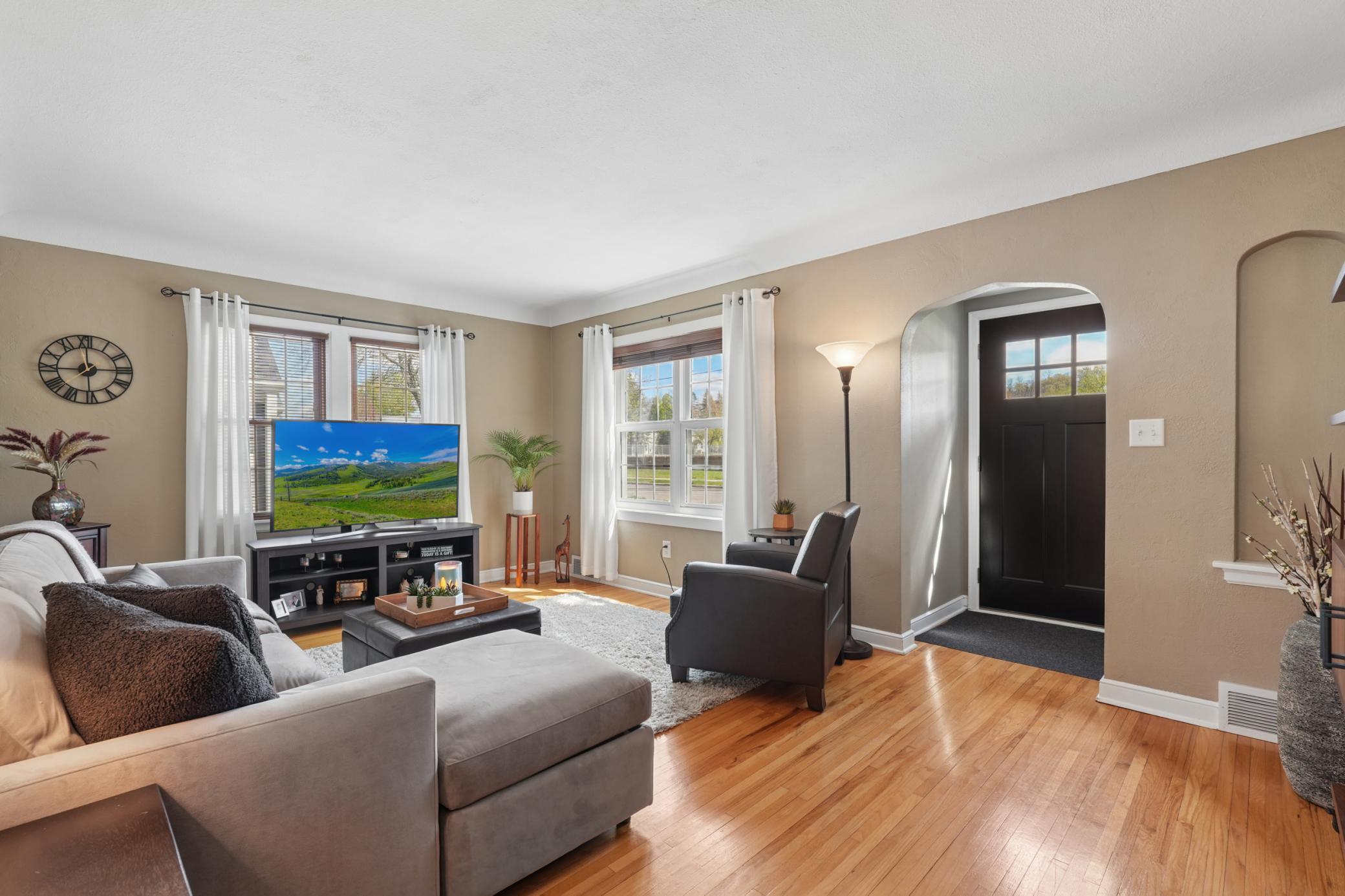 The bright and cheery living room features hardwood floors.