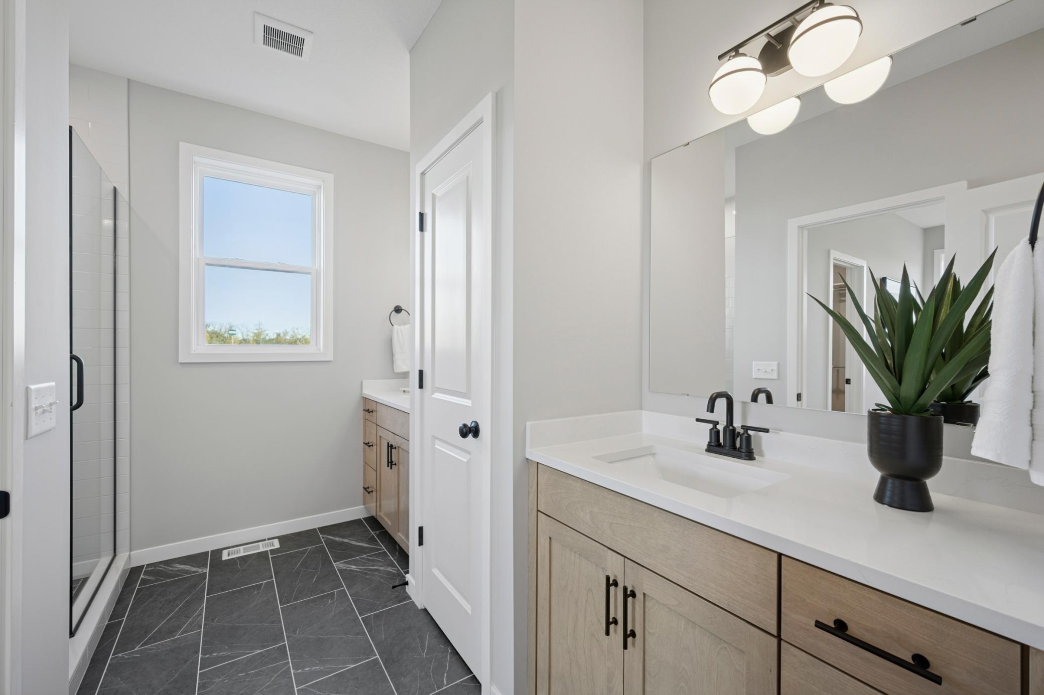 Spacious separate vanities and linen closet tucked in between.