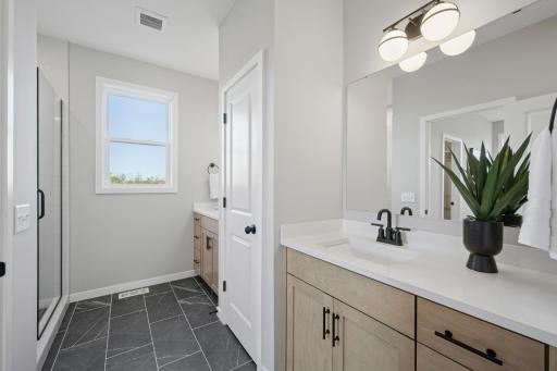 Spacious separate vanities and linen closet tucked in between.