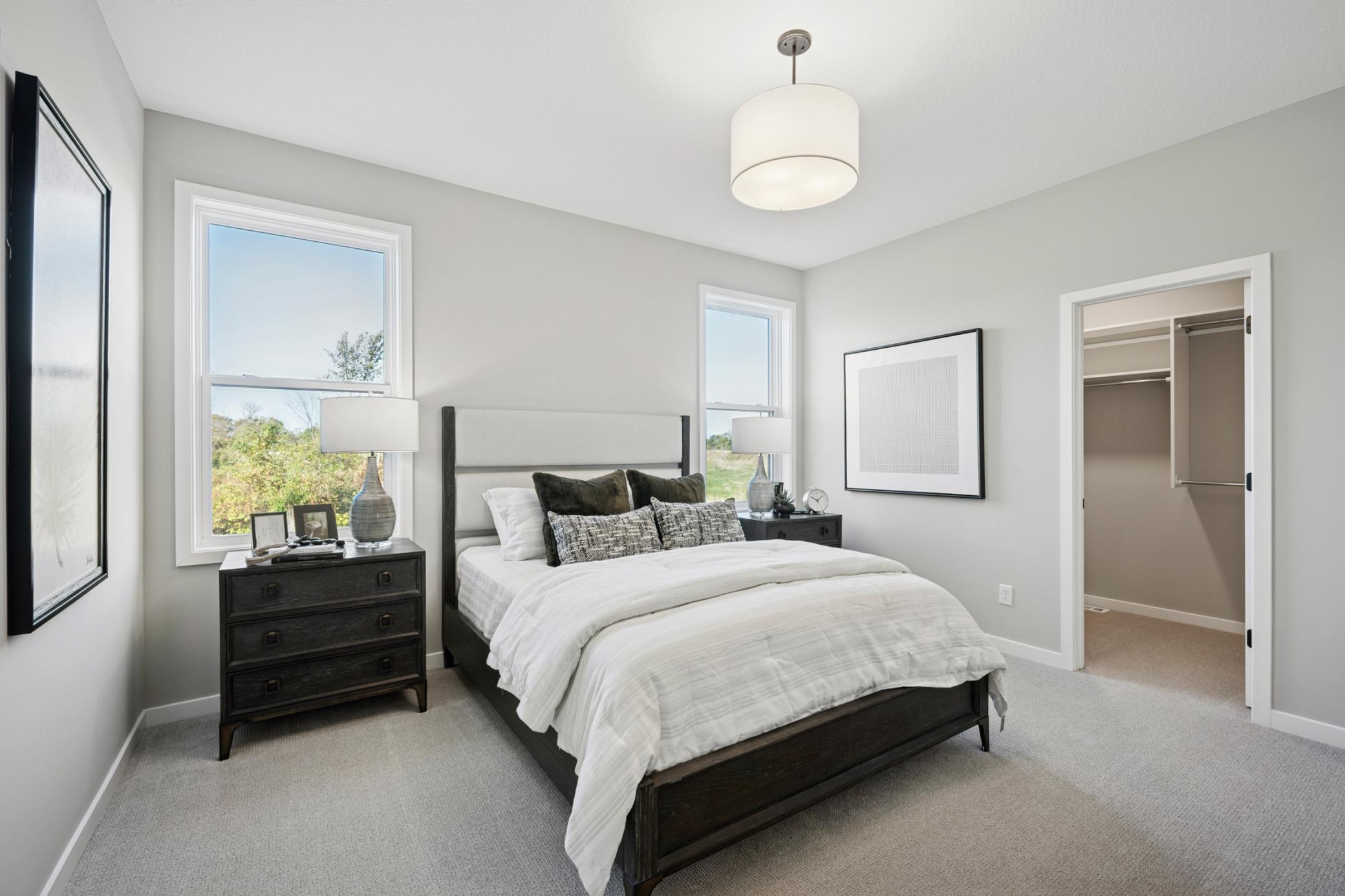 Main Floor Primary Suite with walkin closet, separate vanities and large tiled shower
