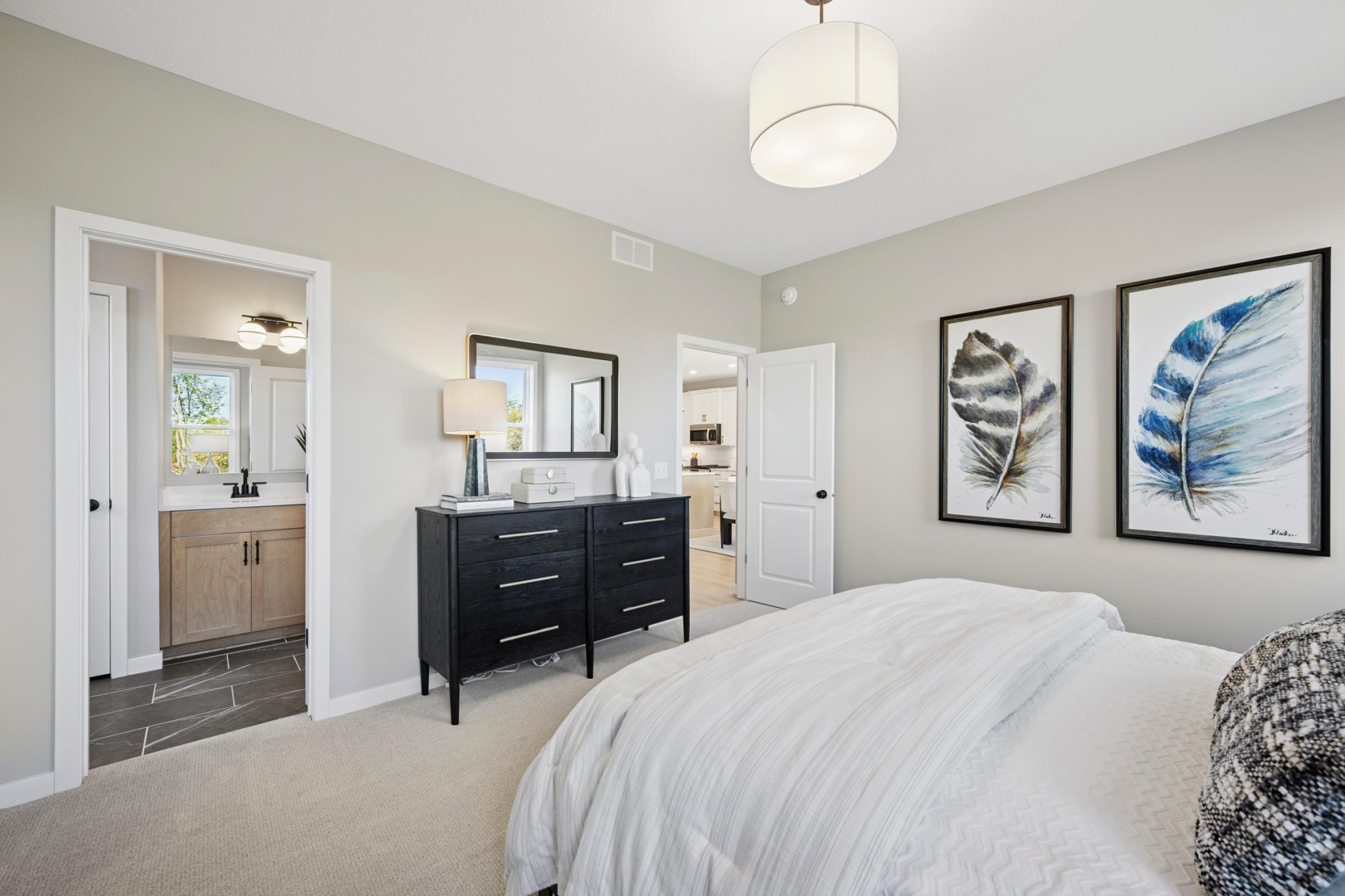 Main Floor Primary Suite with walkin closet, separate vanities and large tiled shower