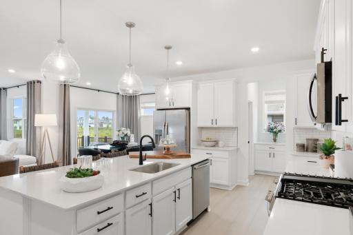Elegant pendant lights at the center island brighten everyday activities