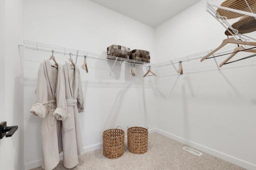 Built-in shelving in this spacious walk-in closet maximizes space and optimizes wardrobe organization