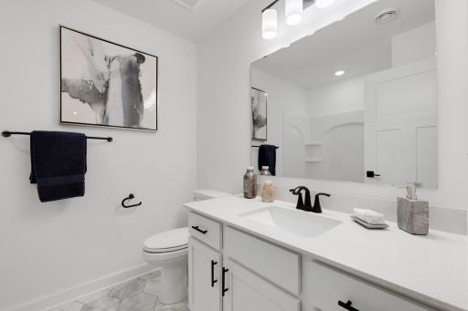 This full-sized bathroom includes a stylish vanity and a shower-tub combo with fiberglass surround