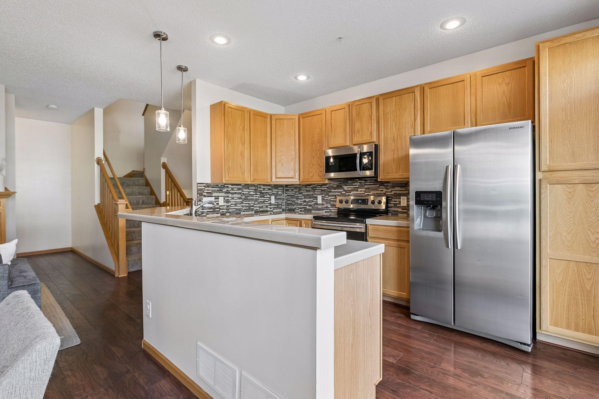 Beautiful kitchen with plenty of cupboard space, stainless steel appliances, and tiled backsplash.