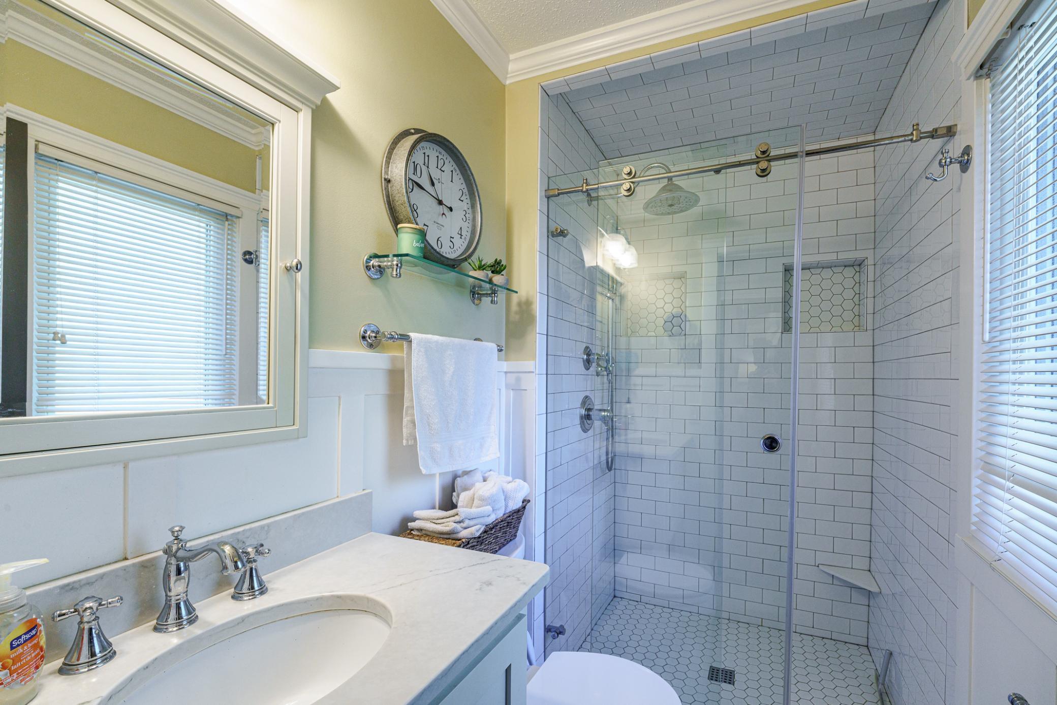 The private 3/4 bath has been remodeled to include a stunning subway tile walk-in shower and an updated vanity and lighting.