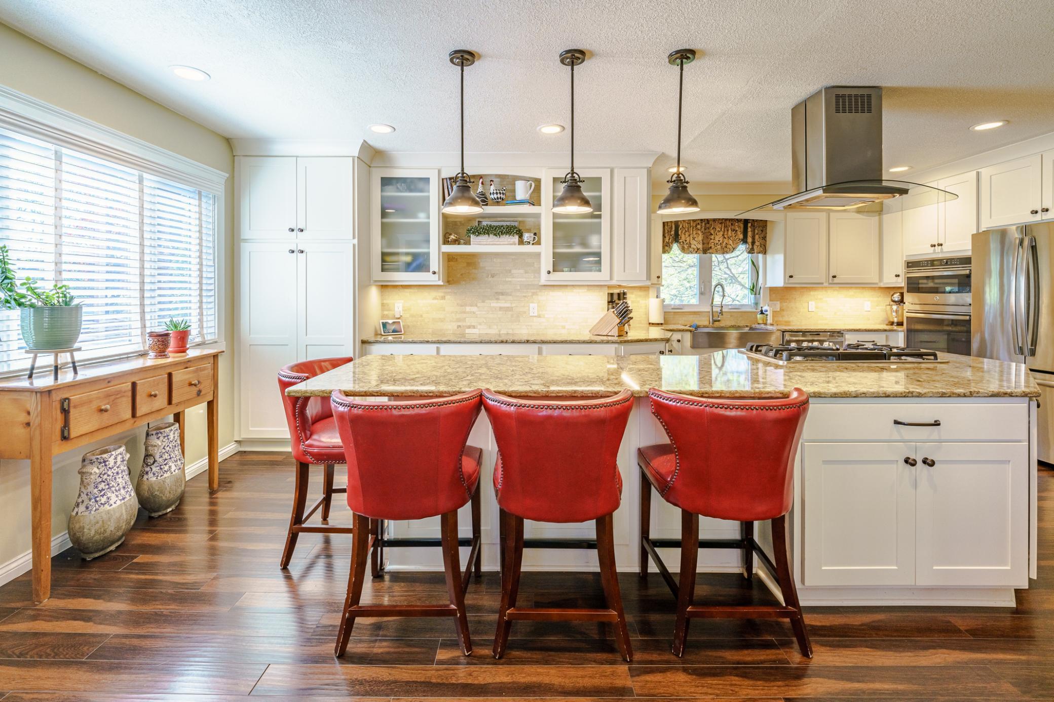 The kitchen underwent a “TO-THE-STUDS” renovation and is simply beautiful! It features stunning white cabinetry against rich wood floors.