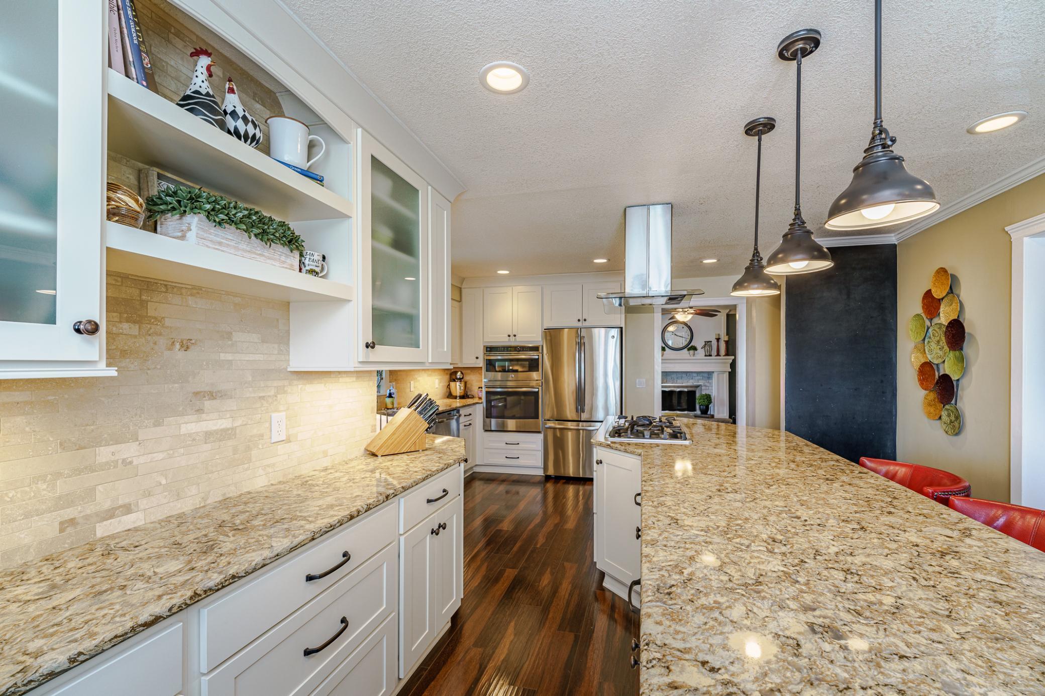 A combination of glass cabinets, shelves and solid cabinets lend visual interest to this space.