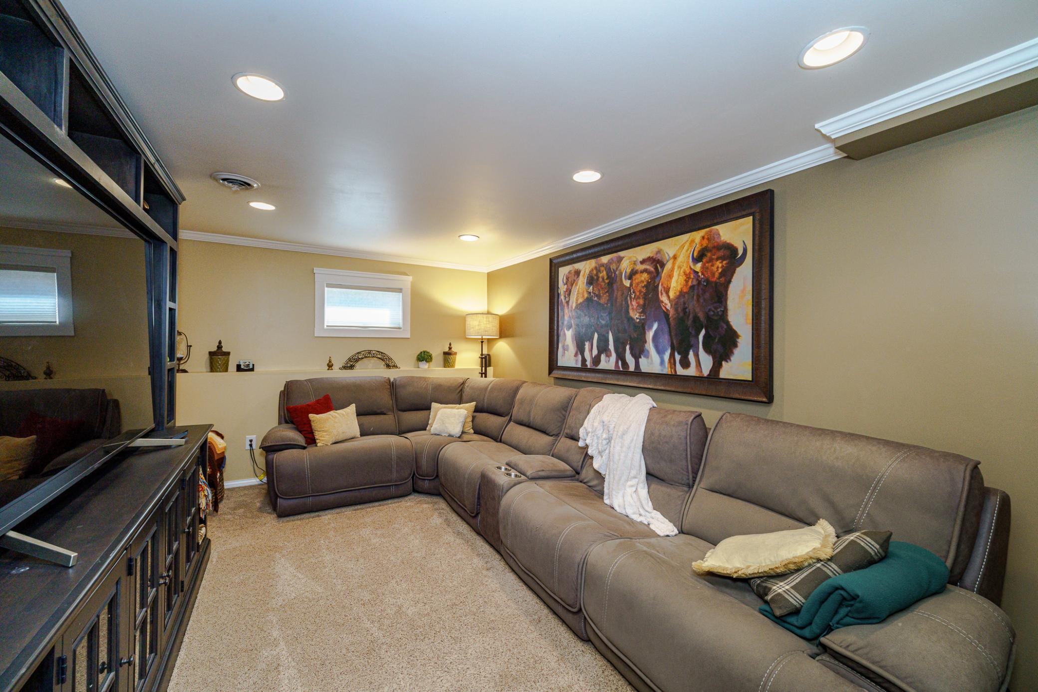The theater room was a previously unfinished space that the seller completed for enjoying relaxing movie nights with family. This space has recessed lighting and white crown molding.