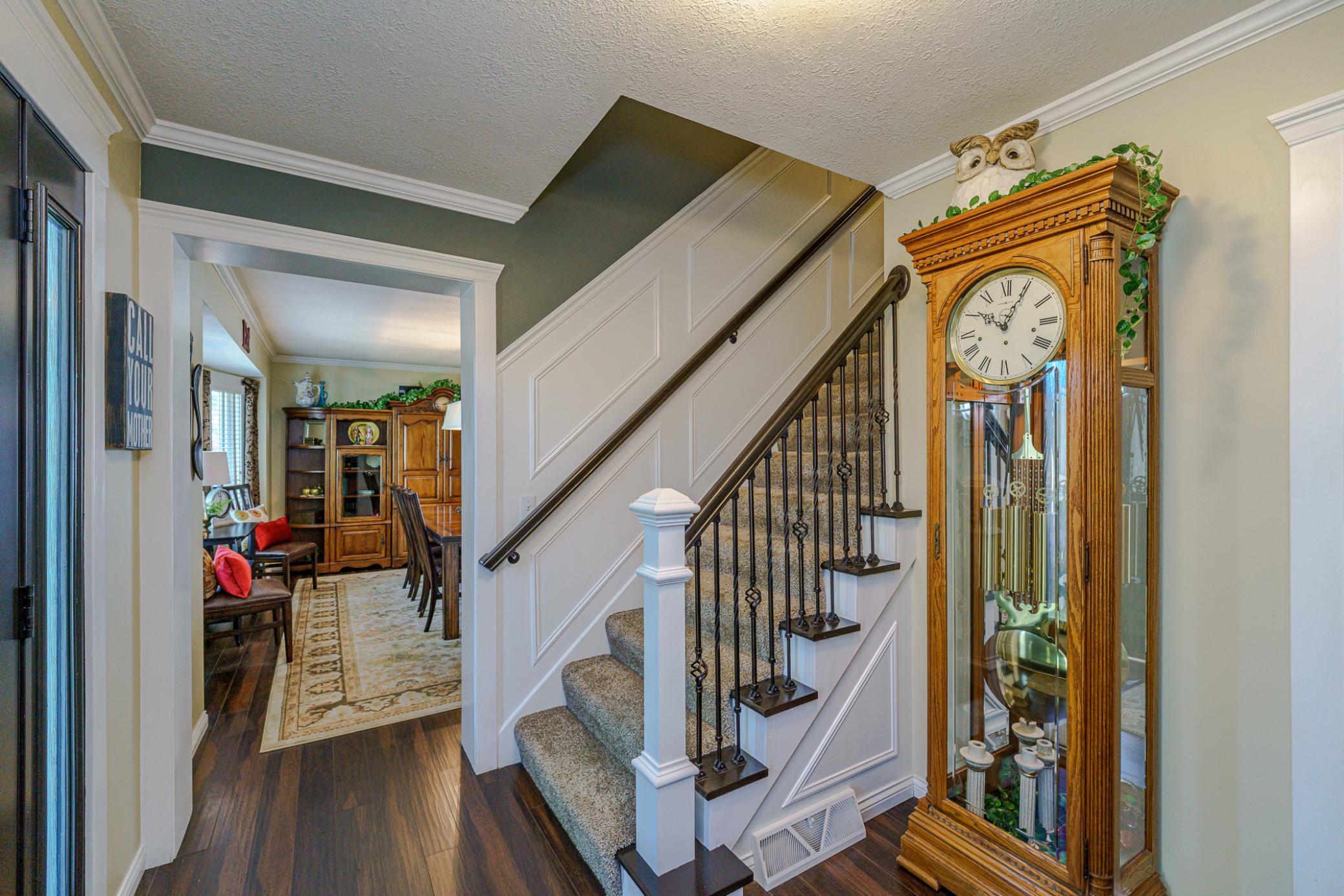 The open staircase has elegant paneled walls to the upper level.
