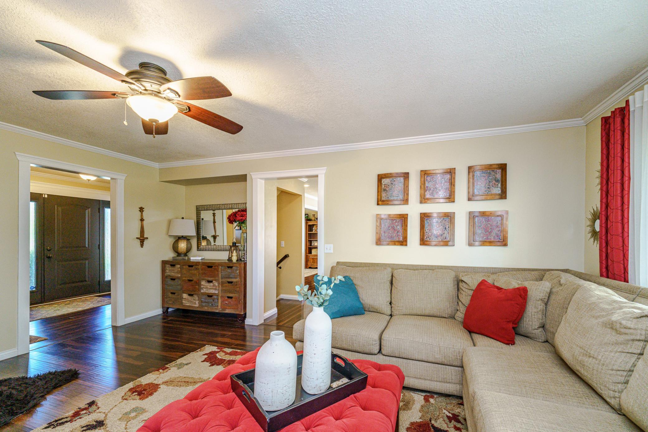 This living room leads to the kitchen and the foyer. This room has a fireplace and leads to the deck.
