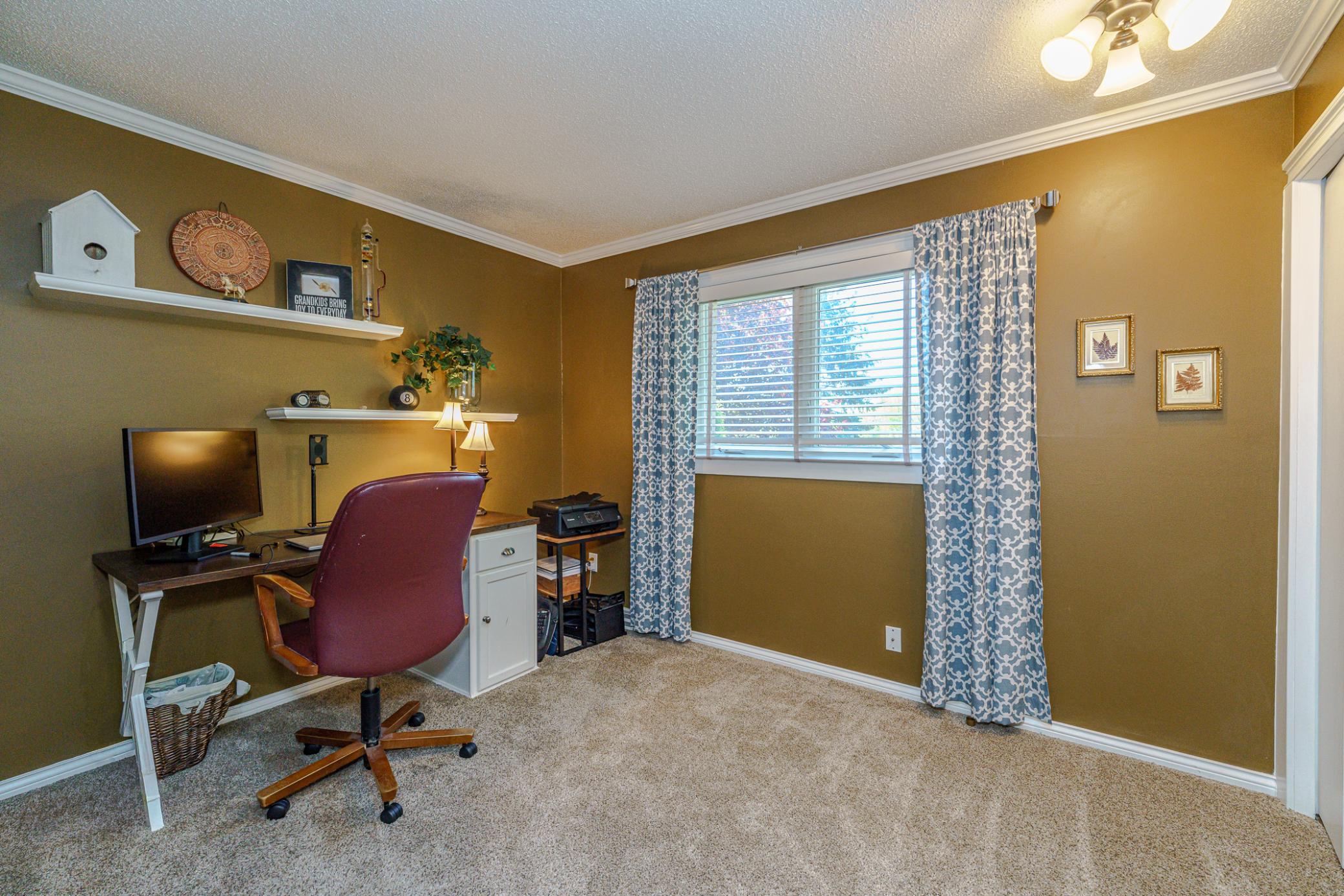 This is one of four upper level bedrooms, with white trim and crown molding.