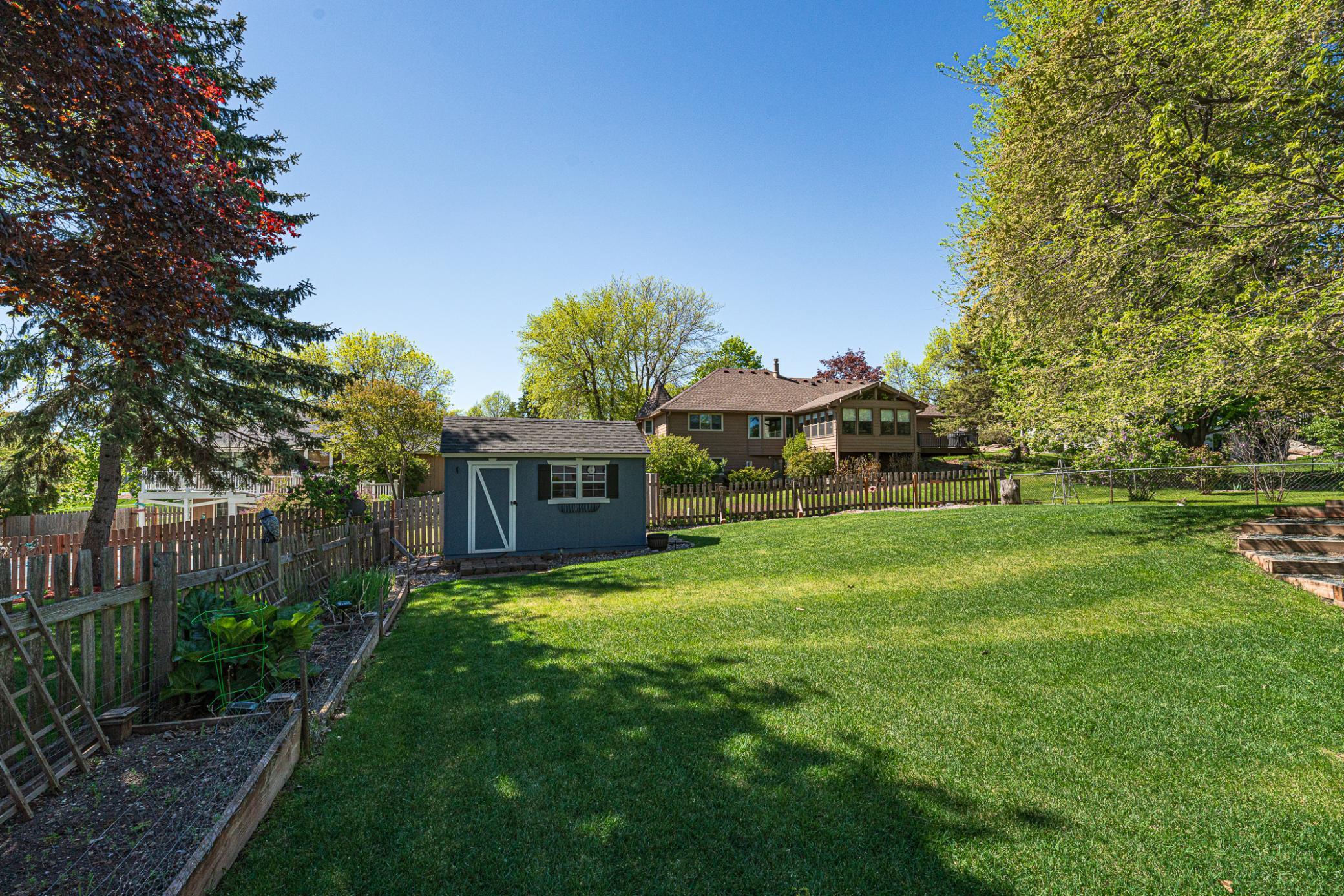 A fenced yard, raised gardens, and a charming storage shed that matches the house are additional amenities.