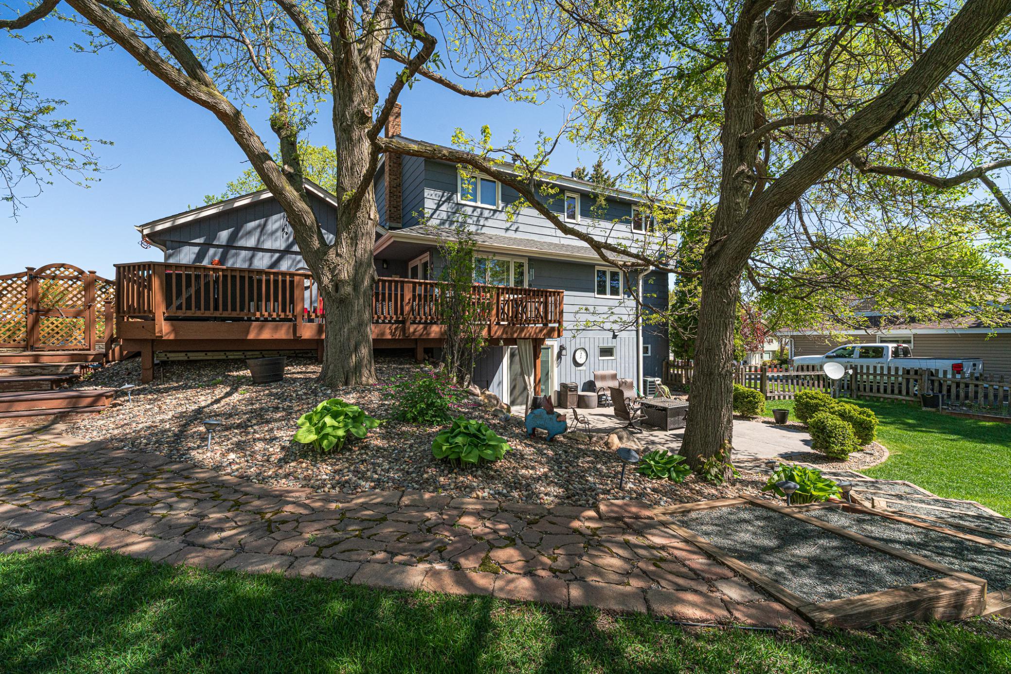 The foot path leads from the deck and garage/parking pad area, down to the backyard and patio.