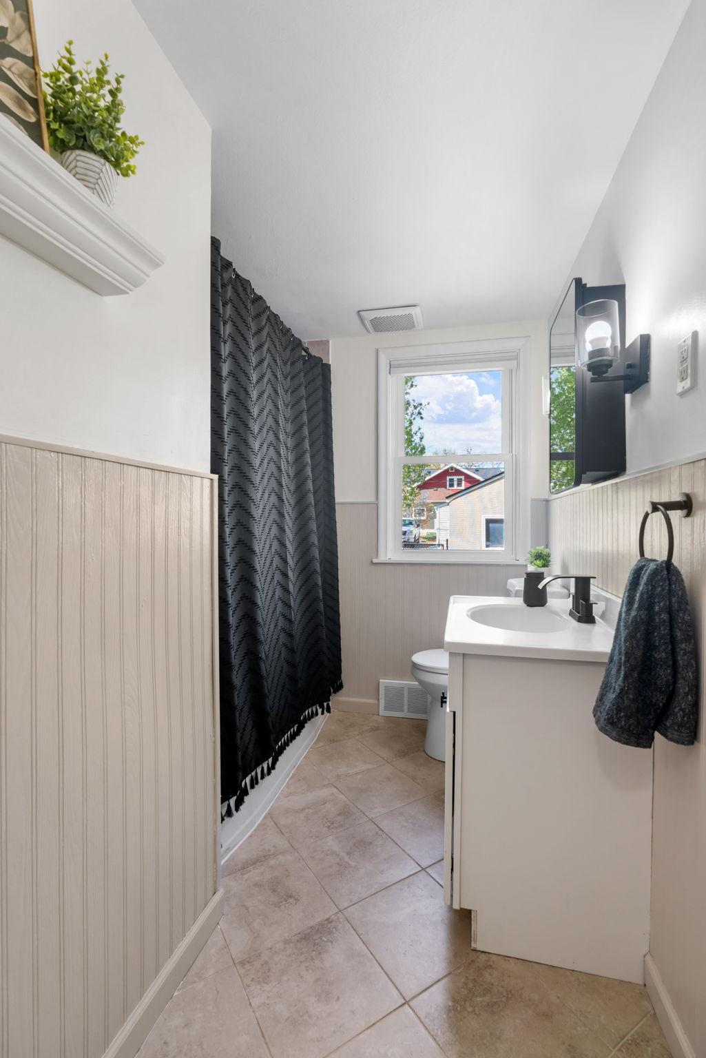 Fully renovated bathroom complete with tiled tub surround, tile floor & updated vanity & toilet.
