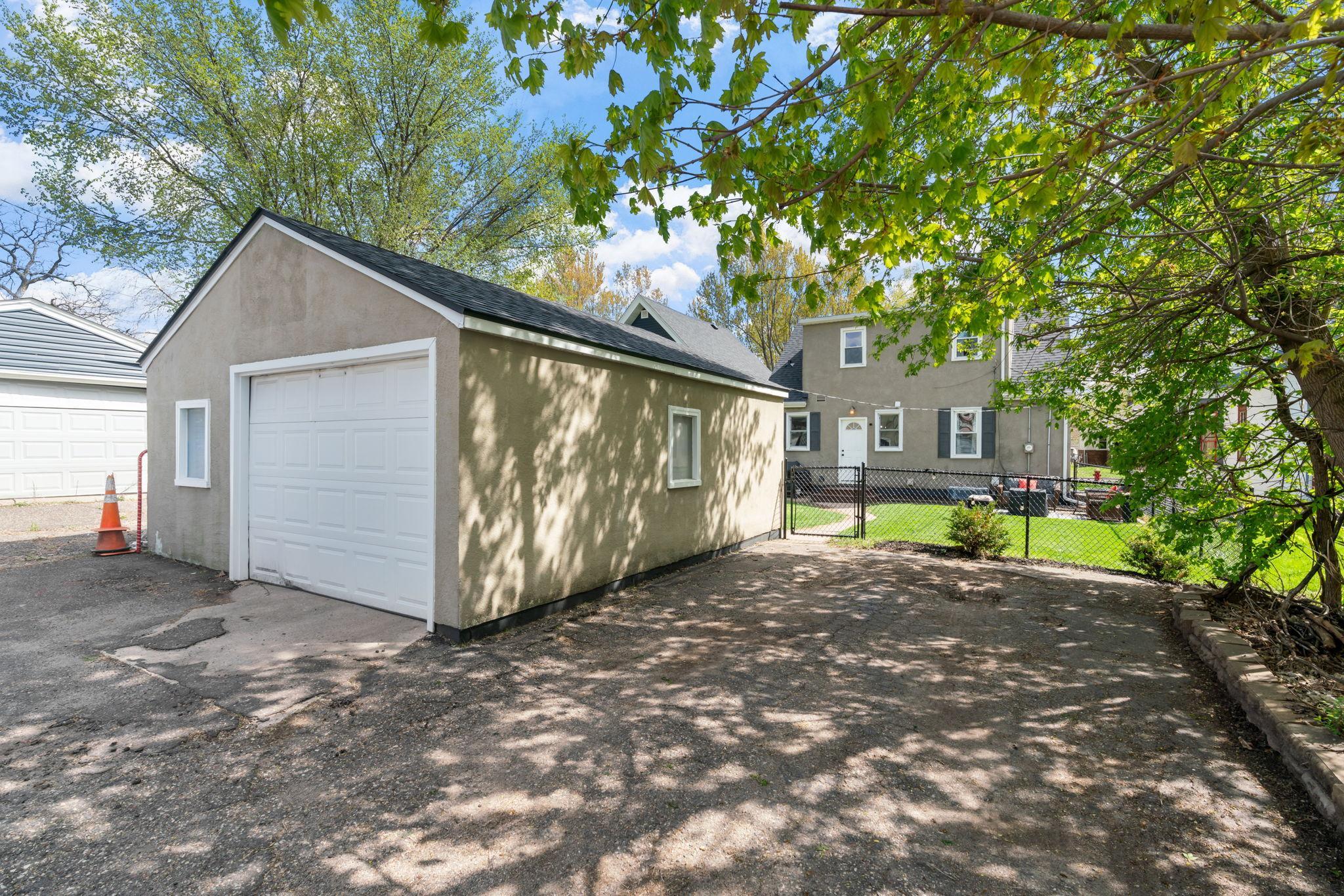 Oversized single car garage with additional adjacent parking pad.