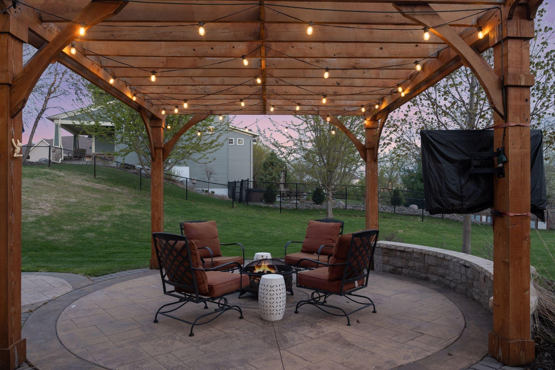 The expansive stamped concrete patio is covered by a pergola and is a great area to enjoy a fire. The sellers will be leaving the TV that is mounted to the pergola.