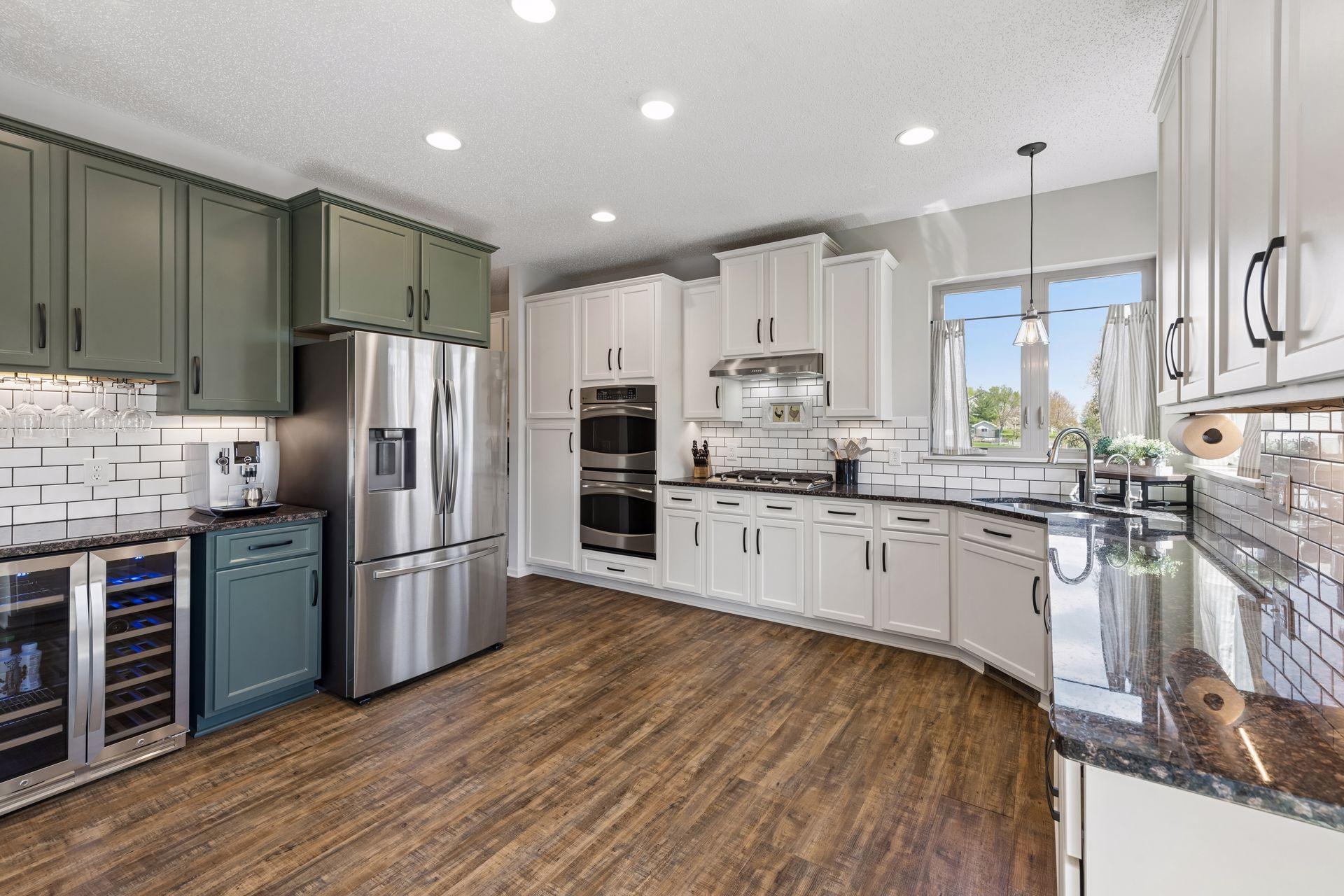 The kitchen has a full suite of stainless steel appliances including a double oven with convection cooking, a gas cooktop, refrigerator, dishwasher and beverage fridge.