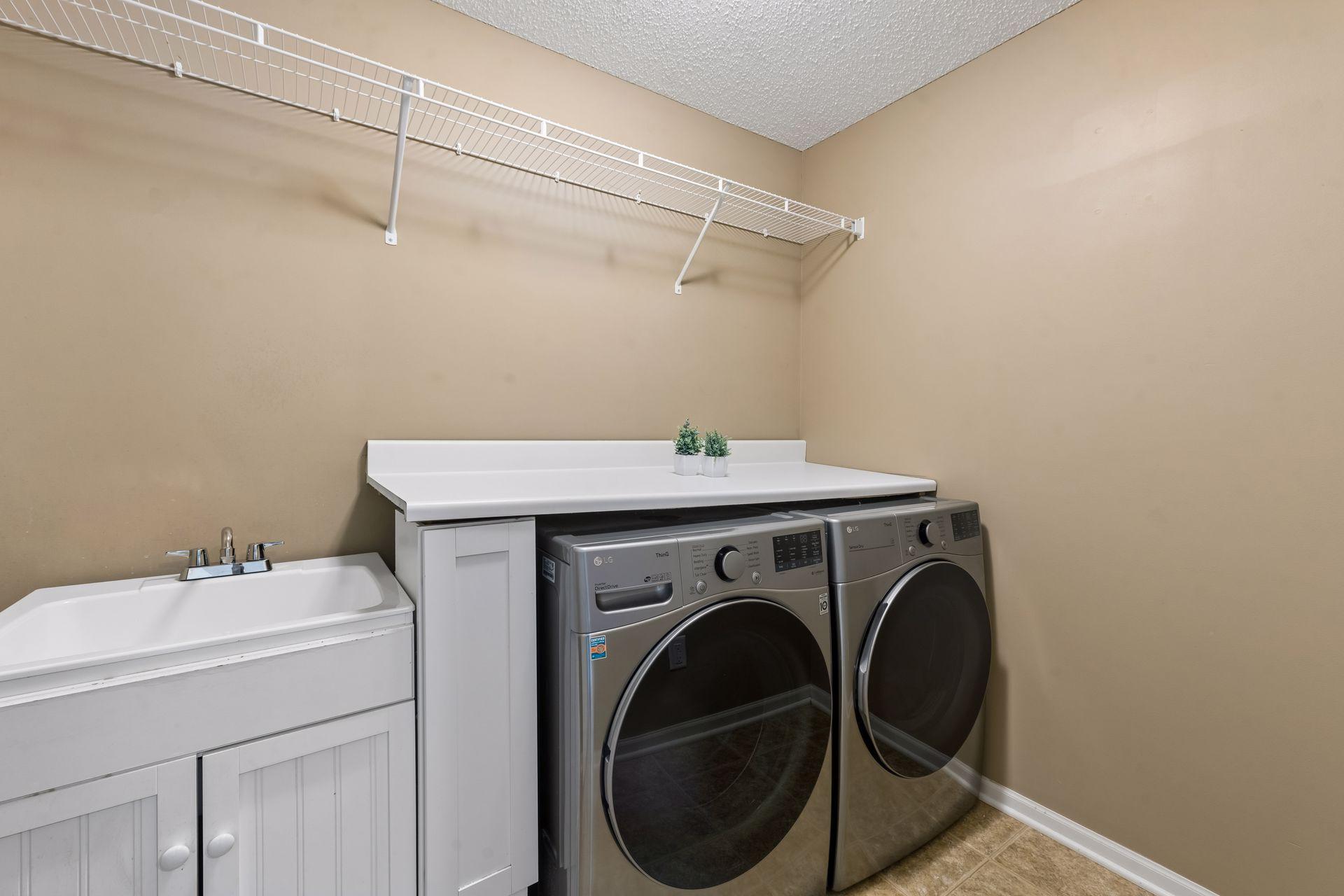 The second floor laundry includes a folding counter, sink and hanging space.