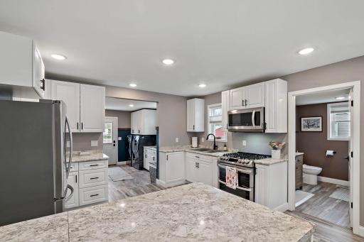 Bright and open kitchen with new cabinets, appliances and lighting.