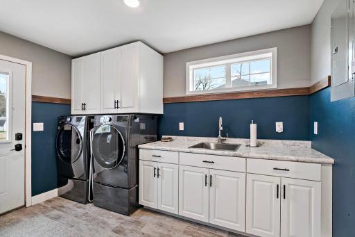 Main floor laundry with cabinets, and front load washer/dryer
