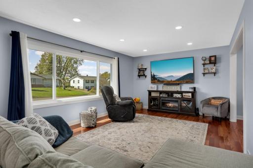 The inviting living room is bathed in light from the newer picture window.