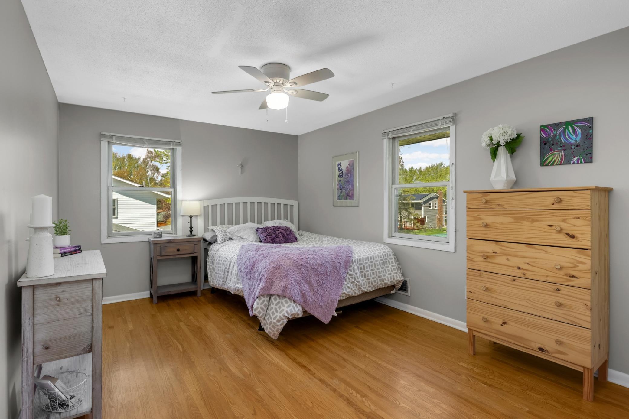 Original hardwoods, a ceiling fan and two windows give this room plenty of warmth and coziness when downtime is needed.