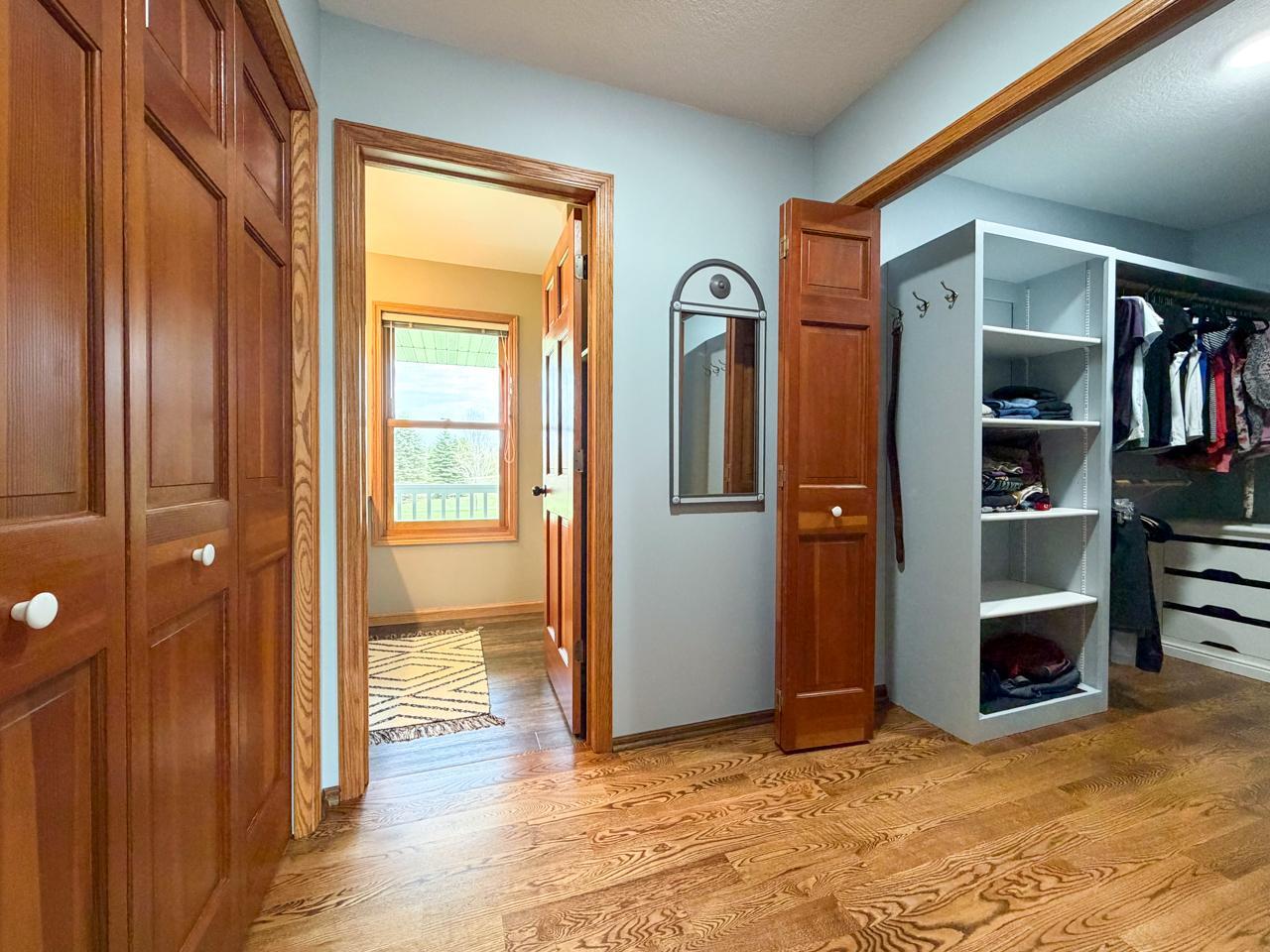 Primary bedroom walk in closet area leading to the bathroom