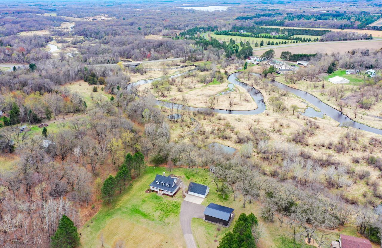 Aerial view of the property. Note that the treeline behind the house gradually goes down to the low land and river.
