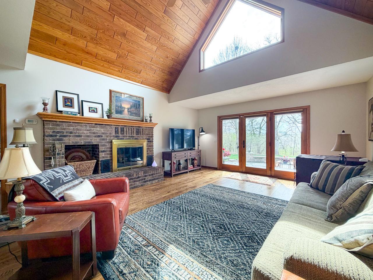Living room with wood burning fireplace and patio door out to the deck and patio area