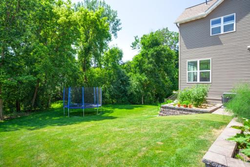 The lush backyard backs to treed privacy and open green space, providing a peaceful retreat with expansive lawn areas, colorful gardens, and a wonderful sense of seclusion rarely found in such a convenient location.