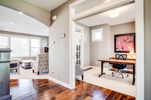Architectural details including arched openings, transom windows, engineered hardwood floors, and custom built-ins & millwork add warmth and character throughout the main level.