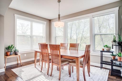 The adjoining dining area is wrapped in windows and natural light with direct access to the maintenance-free deck, creating a seamless indoor-outdoor connection.