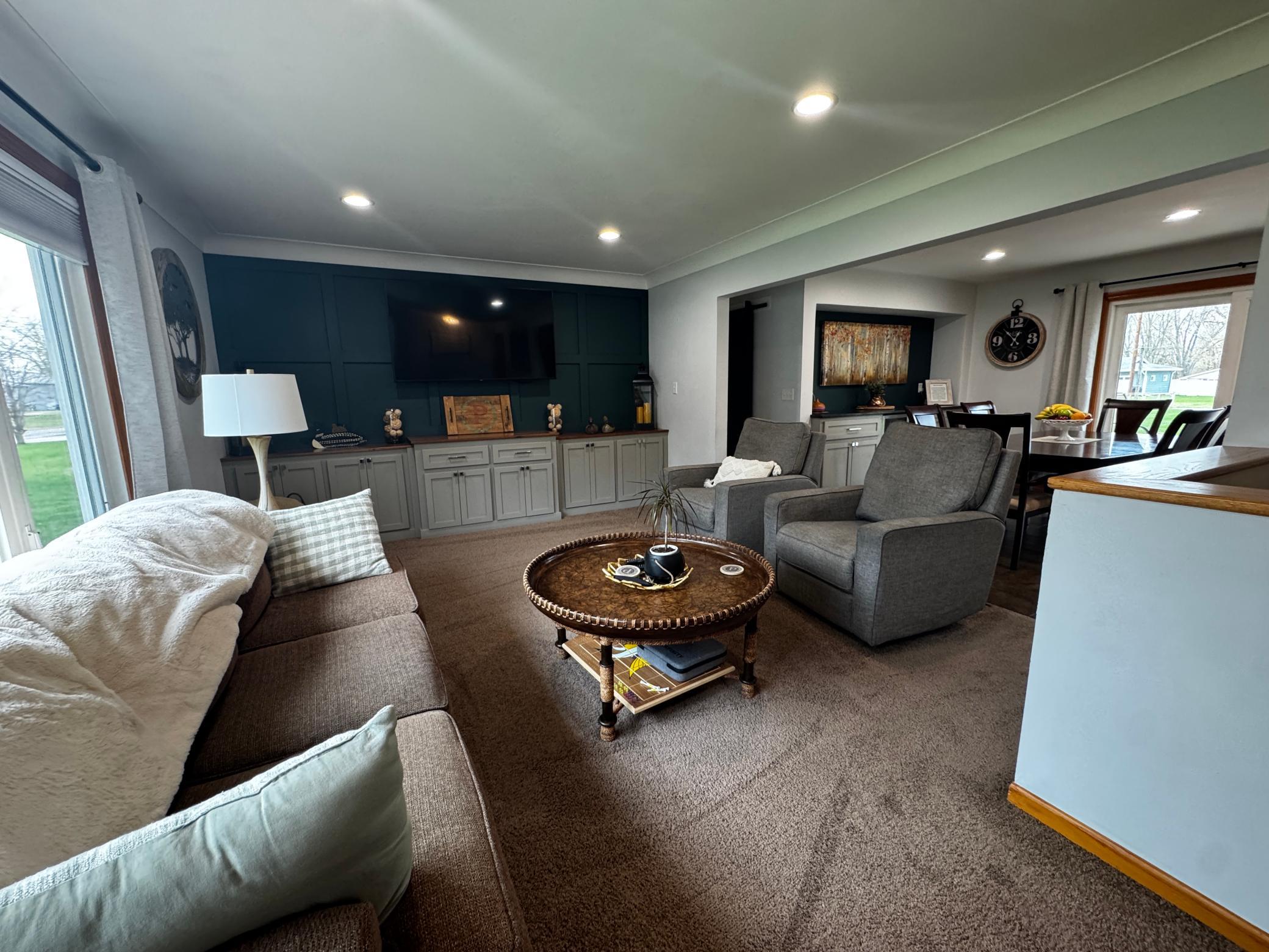 Livingroom-cove ceiling, board and batten accent wall and natural light.