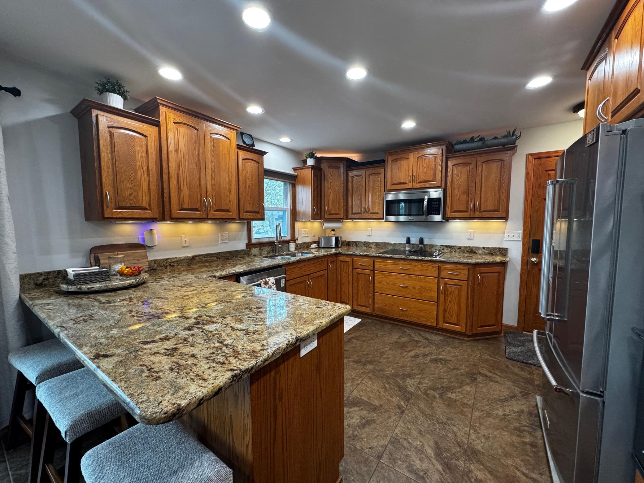 Breakfast bar, granite counter tops under cabinet lighting.