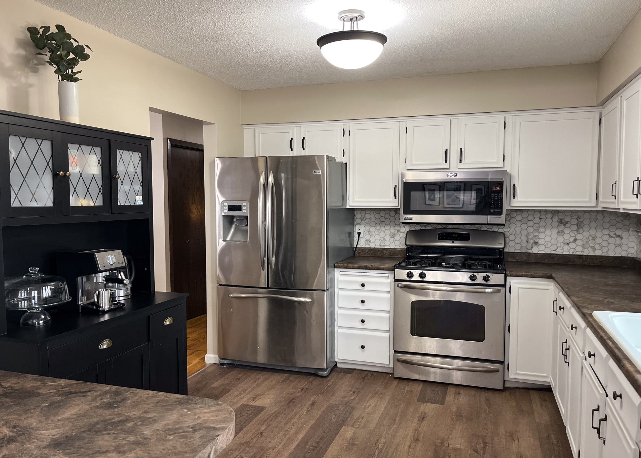 Nice size kitchen with white cabinets and stainless steel appliances
