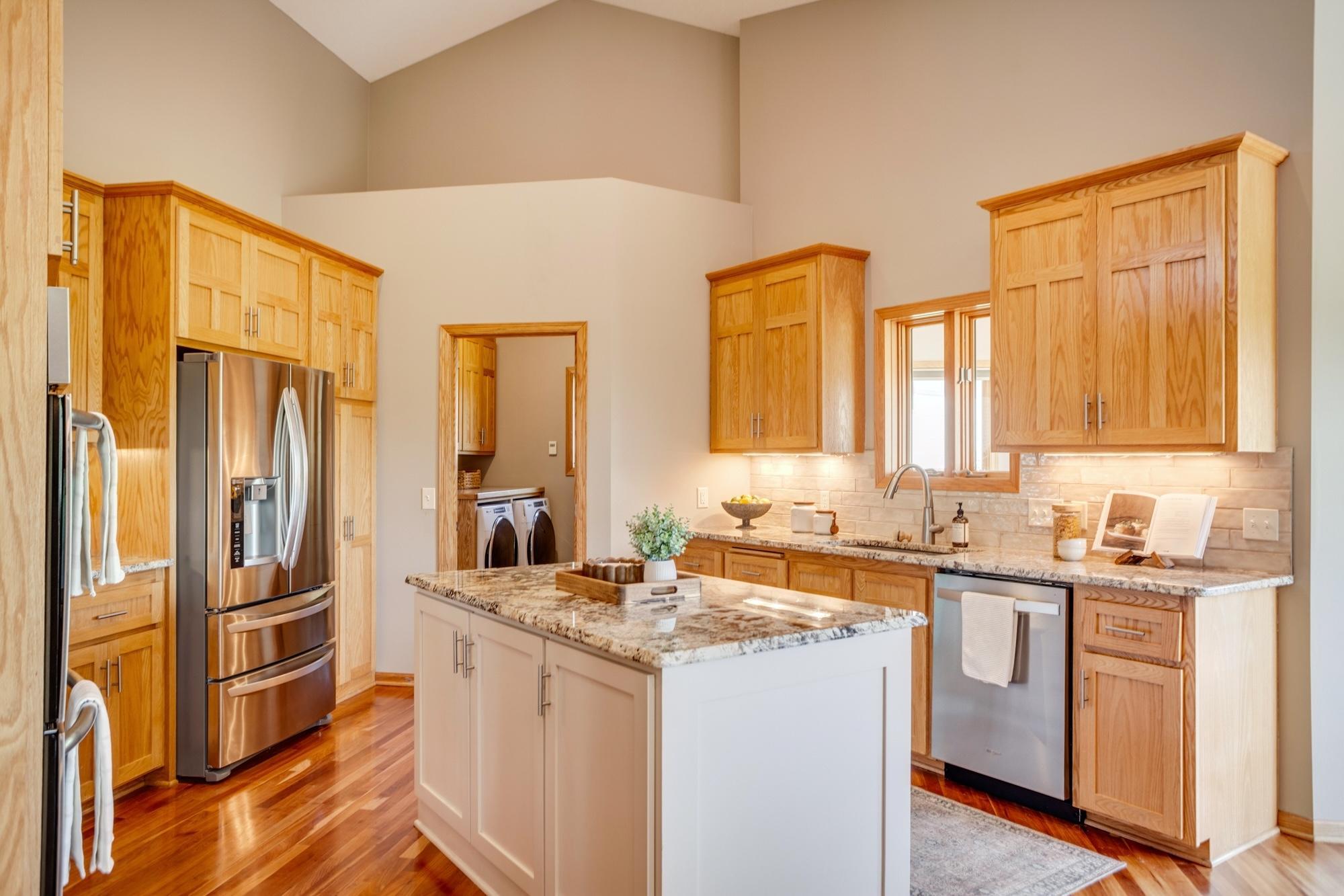 Gourmet kitchen equipped with granite countertops, stainless-steel appliances, a double oven and center island