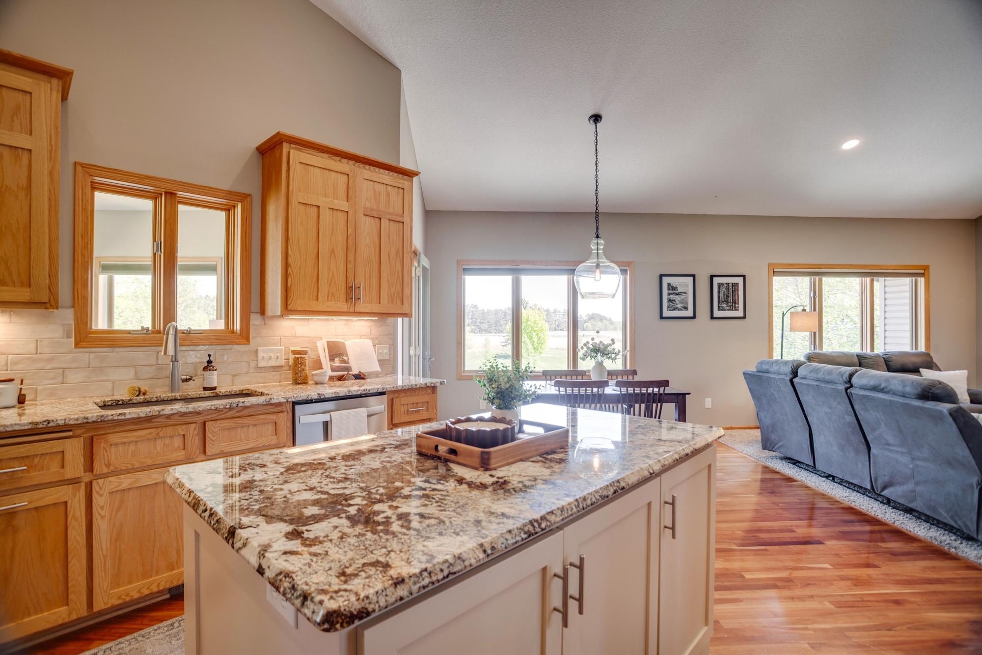 Gourmet kitchen equipped with granite countertops, stainless-steel appliances, a double oven and center island