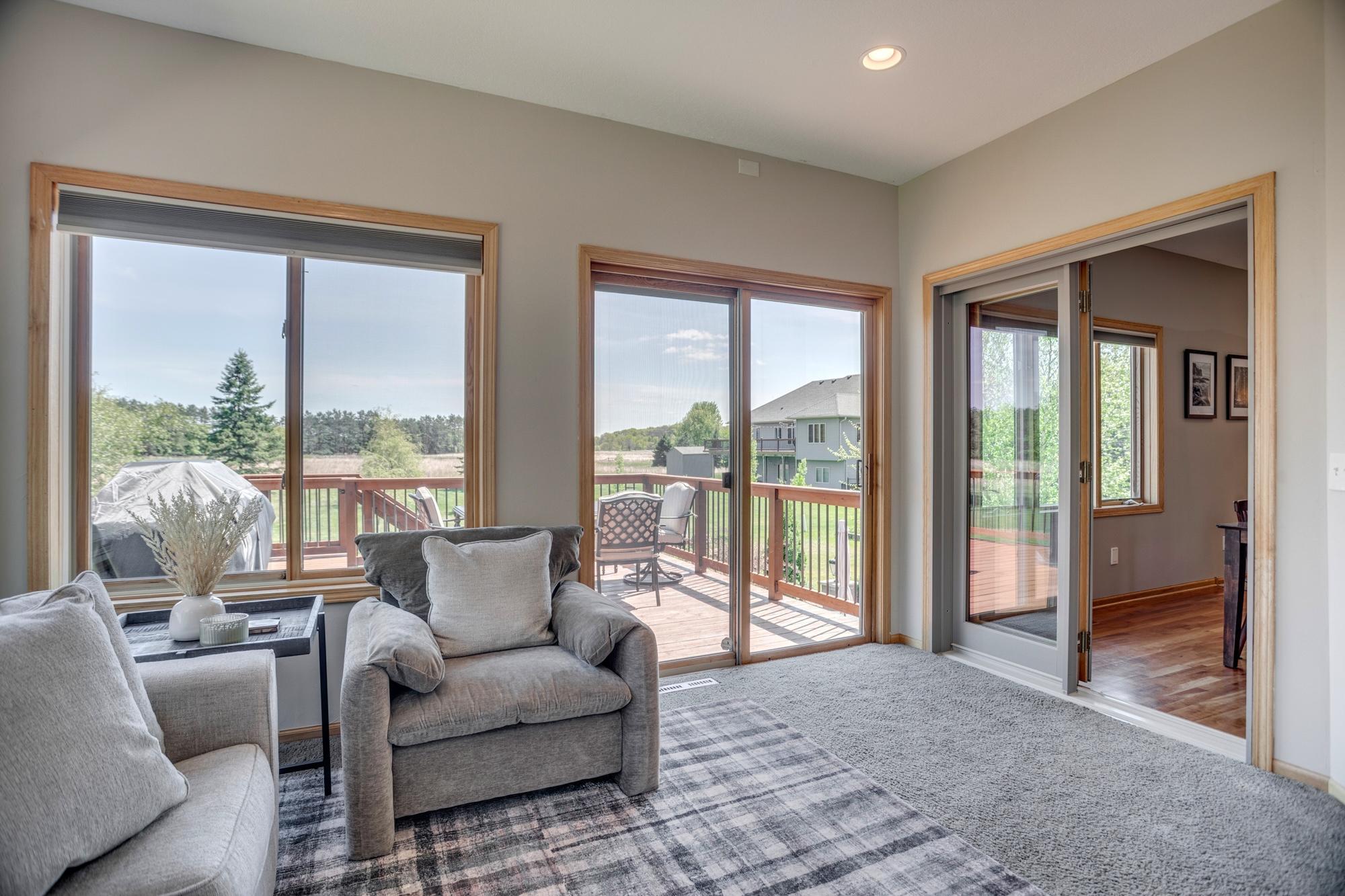 Sunroom with sliding glass doors that open to the deck and wide-open prairie views