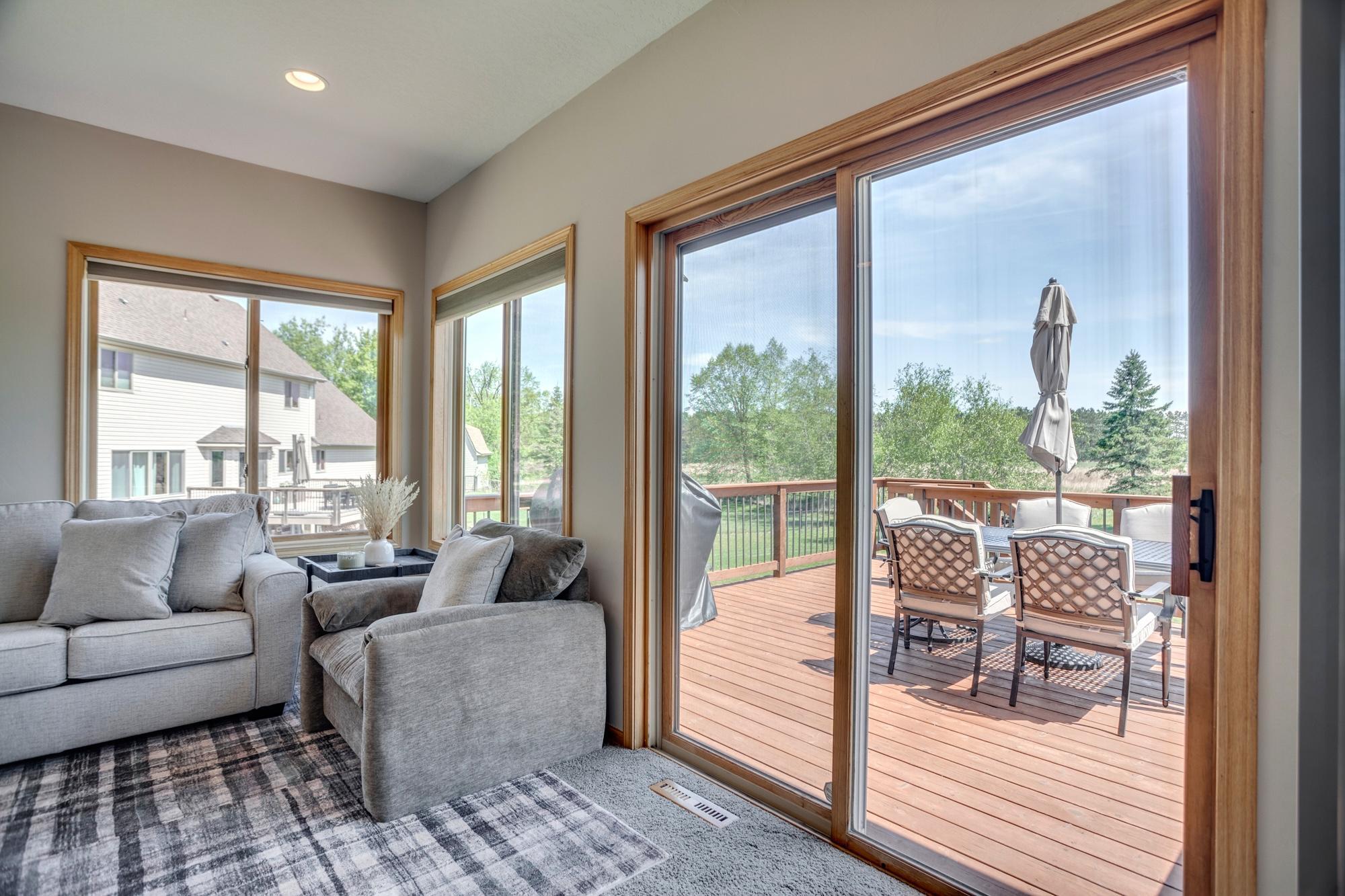 Sunroom with sliding glass doors that open to the deck and wide-open prairie views