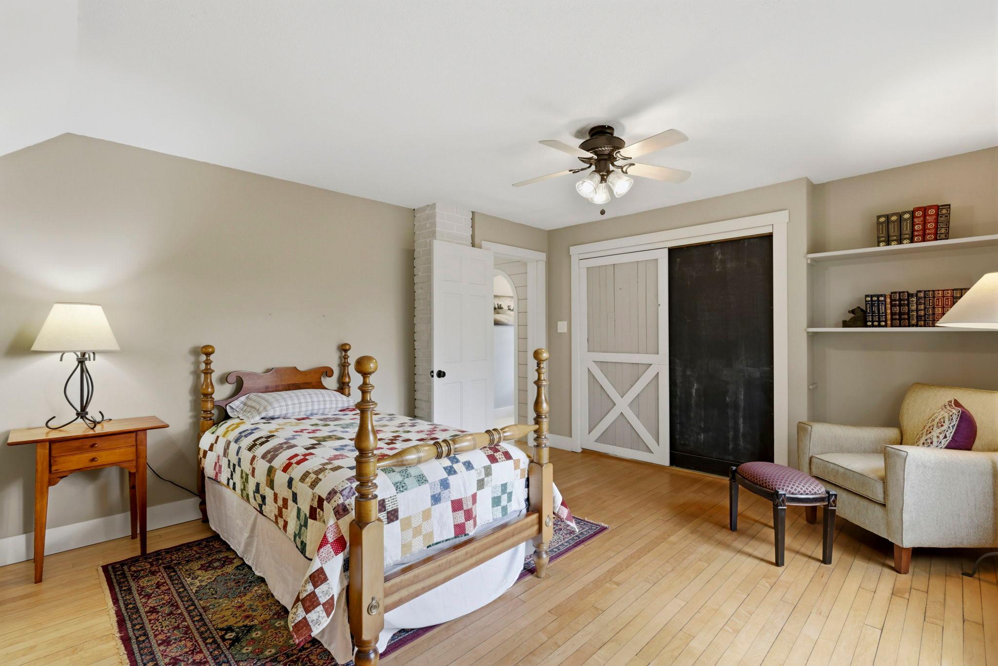 Barn-style sliding door and vintage-inspired details add warmth and personality to this peaceful bedroom retreat.